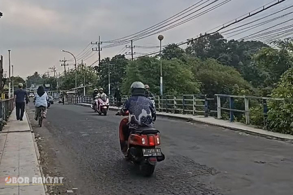 Bondowoso, Obor Rakyat — Keputusan pembukaan pembatas jalan (portal) di Jembatan Koncer di Kabupaten Bondowoso, pada Minggu malam (18/10/2026) memicu sorotan tajam masyarakat. Kebijakan ini dinilai berisiko tinggi terhadap keselamatan pengguna jalan, mengingat kondisi fisik jembatan baja tersebut saat ini mengalami degradasi struktural mendasar akibat korosi berat dan deformasi material.